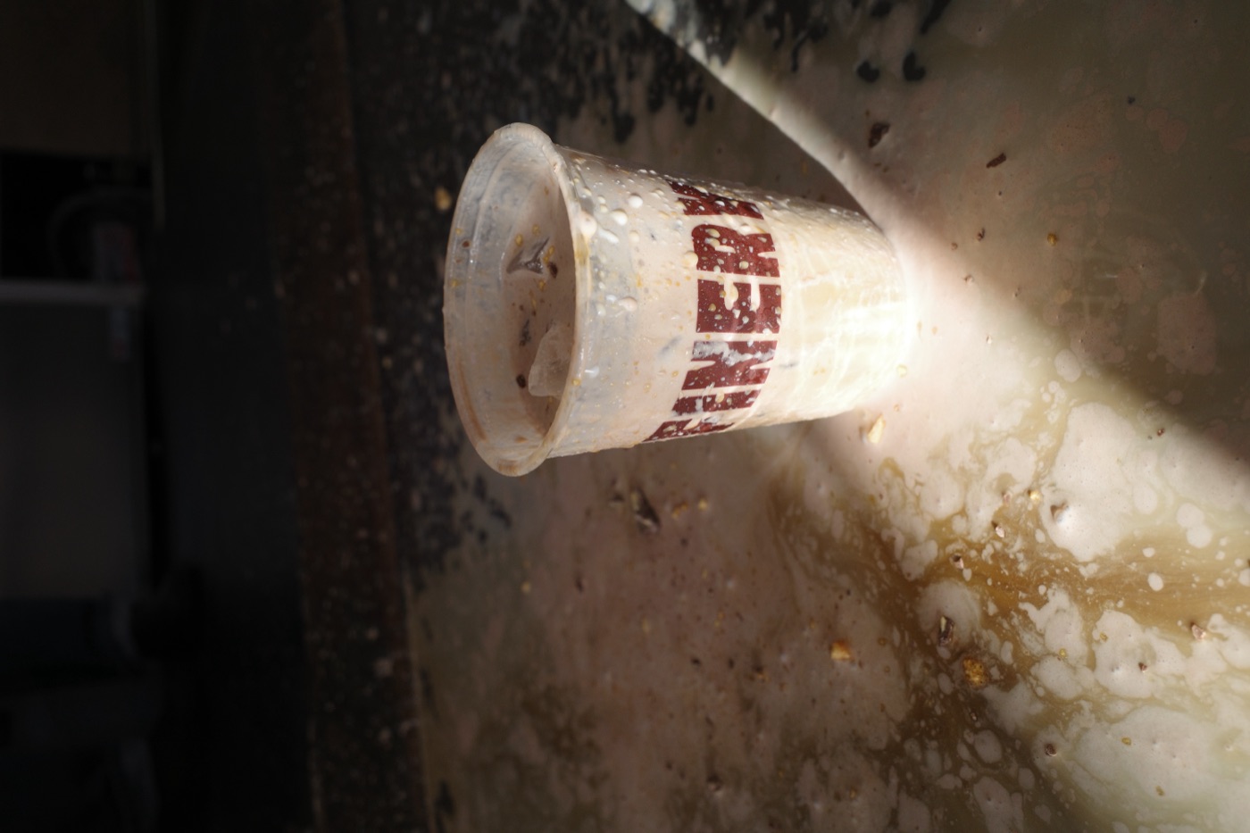 Cold foam iced coffee dripping down a Refinery Coffee cup in afternoon light, Currumbin